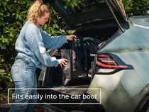 Person loading the TentBox CoolBag into the car boot with text 'Fits easily into the car boot'.